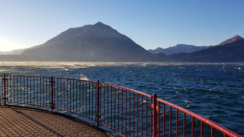 Scenic view of sea and mountains against clear blue sky