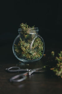 Close-up of glass jar on table against black background