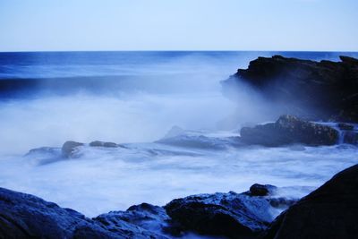 Scenic view of sea and mountains against clear sky