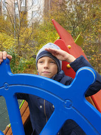 Close-up of boy saluting while standing park