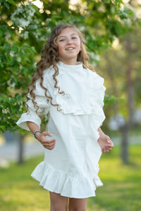 Portrait of smiling girl standing against plants