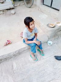 High angle view of cute girl sitting outdoors