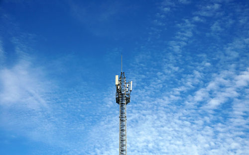 Low angle view of communications tower against blue sky