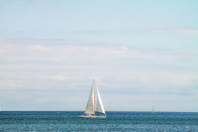 Sailboat sailing on sea against sky