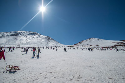 People on snowcapped mountain against sky