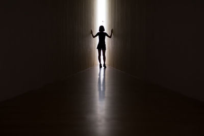 Rear view of silhouette girl standing in corridor