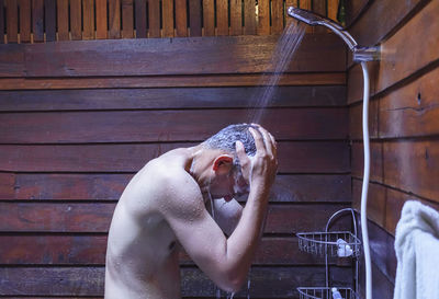 Full length of shirtless man in bathroom