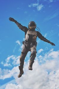 Low angle view of man flying against sky