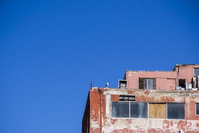 Abandoned building against clear blue sky