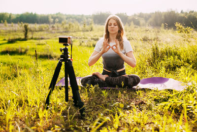 The girl practices yoga in nature and records a video lesson about yoga. yoga online