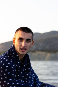 Portrait of young man against sky