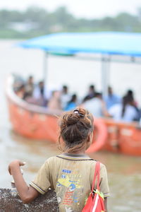 Rear view of woman sitting outdoors