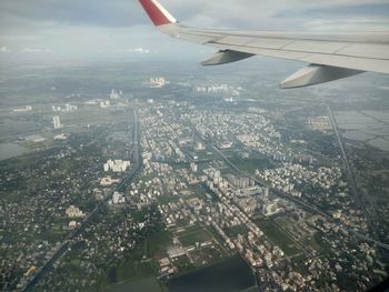 Aerial view of airplane wing over cityscape