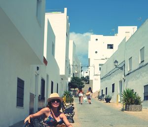 Portrait of woman on street against buildings in city