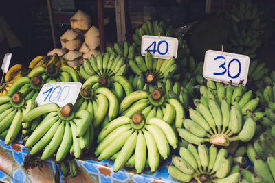 Green bananas for sale at market stall