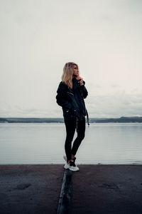 Full length of woman standing on sea against sky