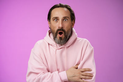 Portrait of man against pink background