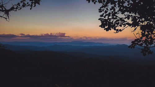 Scenic view of silhouette mountains against sky at sunset