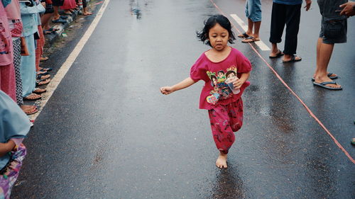 Full length portrait of happy girl on street in city