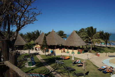 Houses by swimming pool against clear blue sky