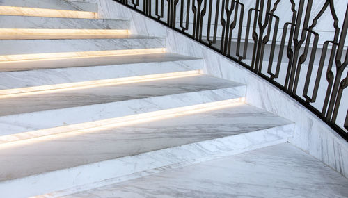 White marble staircase and light with wrought iron banister leading up