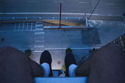 Low section of person sitting over road