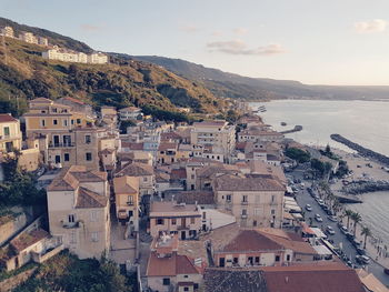 High angle view of houses by sea against sky