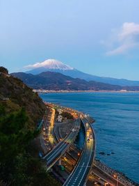 High angle view of road by sea against blue sky