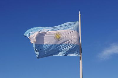 Low angle view of an argentinian flag against blue sky