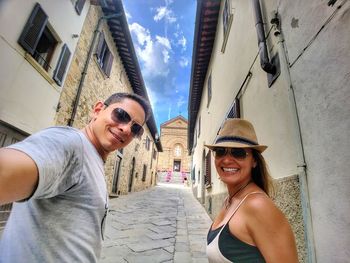 Portrait of smiling friends standing in alley