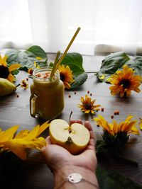 Close-up of hand holding flowers on table