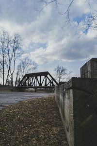 Bare trees against cloudy sky