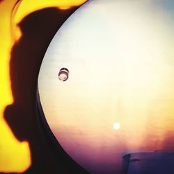 Close-up of airplane against sky during sunset