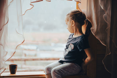 Side view of young woman using mobile phone