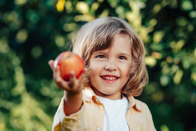 Portrait of young woman holding apple