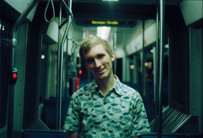 Portrait of smiling young man in train
