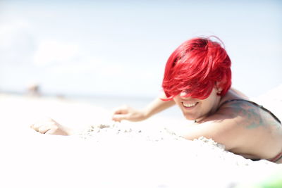 Side view of woman sitting on sand at home