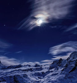 Scenic view of snowcapped mountains against sky at night