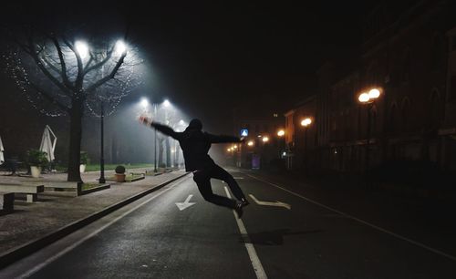 Man jumping on road at night