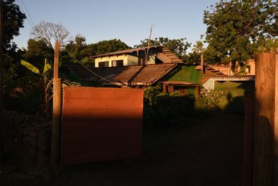 House amidst trees and buildings against sky