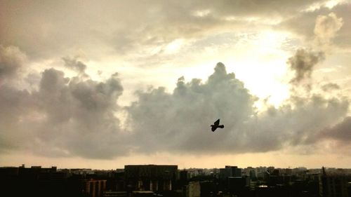 Low angle view of airplane flying against cloudy sky