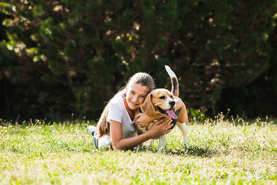 Portrait of girl playing with dog outdoors