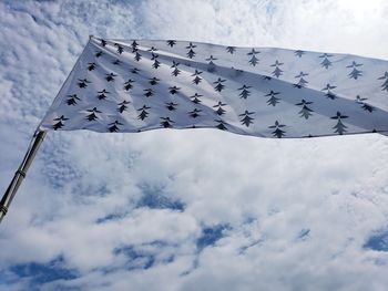 Low angle view of flag against cloudy sky