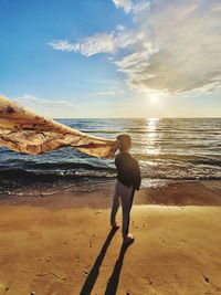 Full length of man standing on beach against sky