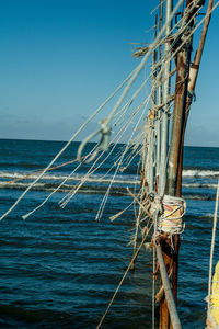 Sailboat sailing on sea against clear blue sky