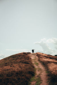 Man riding on field against sky