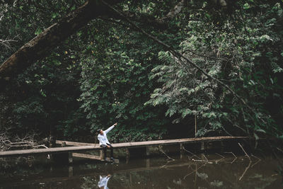 Side view of man walking by plants in forest