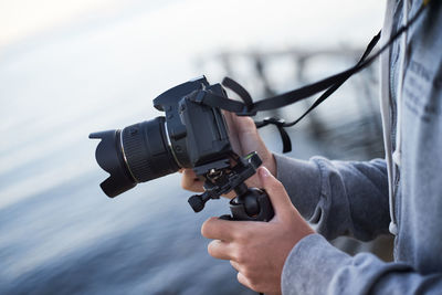 Midsection of man holding camera