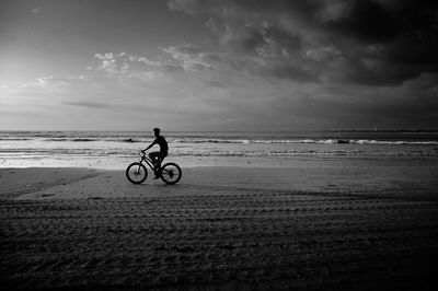 Man riding bicycle on beach