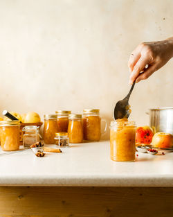 Woman filling glass jars with homemade apple sauce